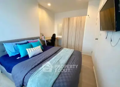 Modern bedroom with stylish decor and wall-mounted TV, perfect for comfort and relaxation.