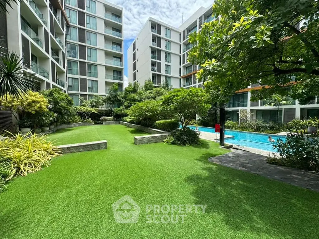 Modern apartment complex with lush garden and pool area