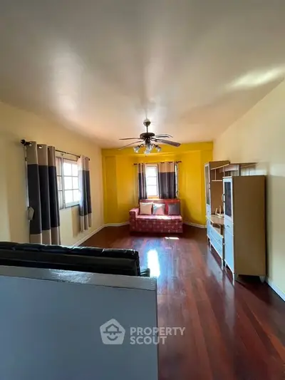 Spacious living room with hardwood floors and cozy seating area.