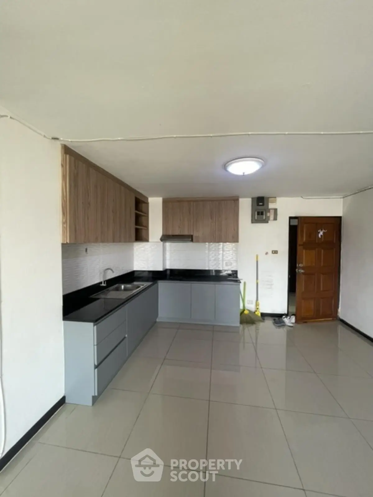 Modern kitchen with sleek cabinetry and tiled flooring in a spacious apartment.