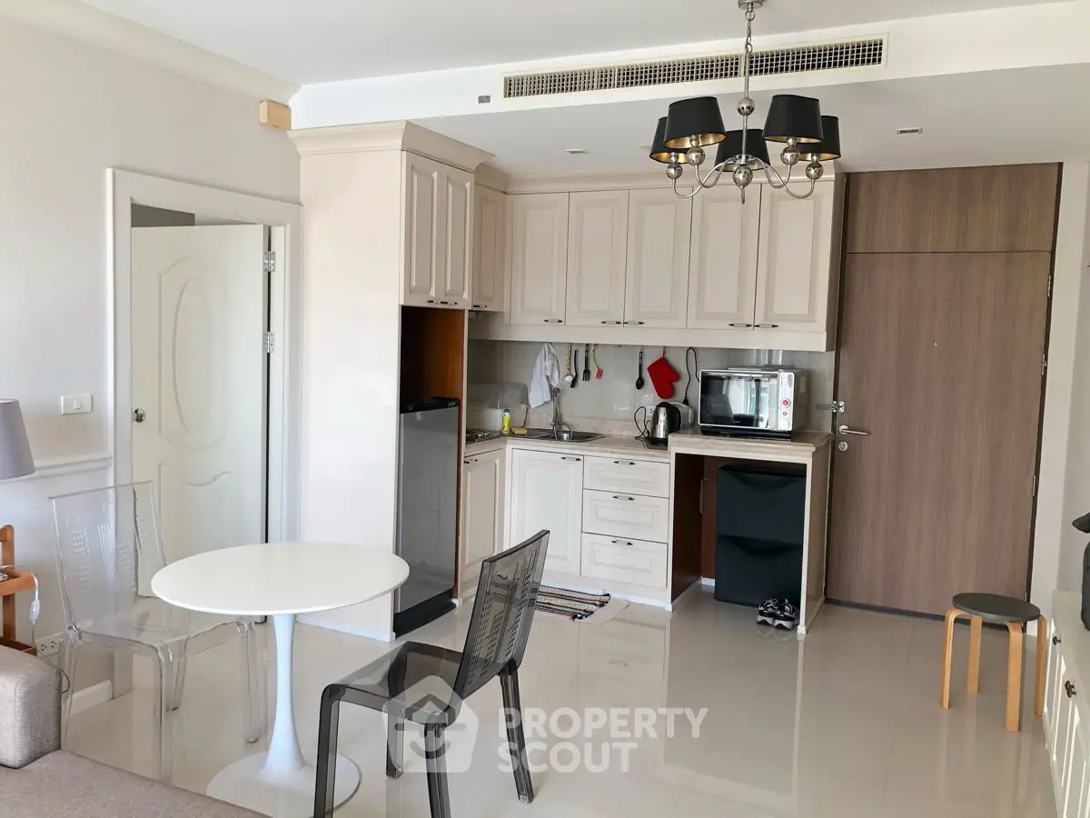 Modern kitchen with sleek cabinetry and dining area in a stylish apartment.