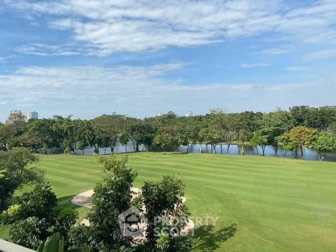 Stunning golf course view with lush greenery and serene water backdrop.