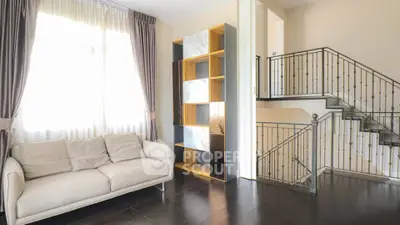 Elegant living room with modern staircase and cozy sofa