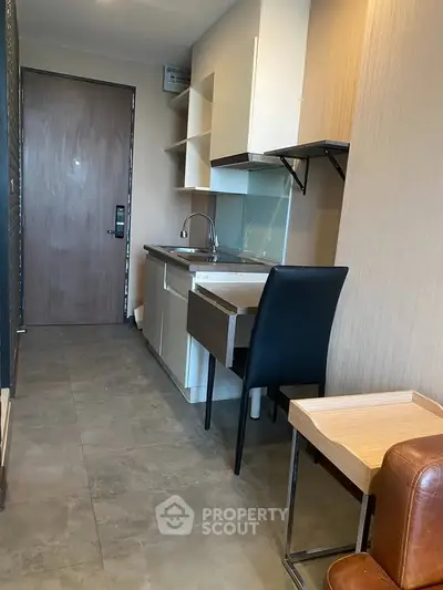 Compact modern kitchen with sleek cabinetry and integrated appliances in a cozy apartment setting.