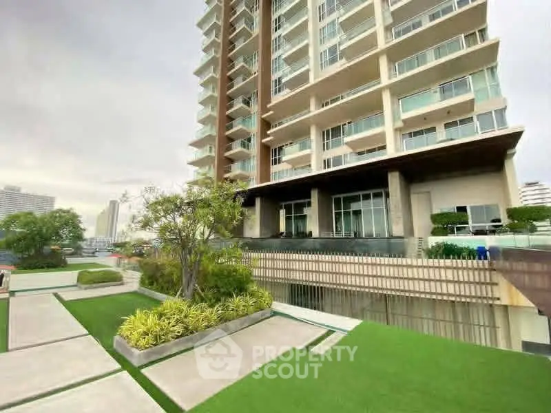 Modern high-rise building with landscaped garden and spacious balconies.