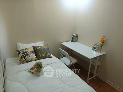 Cozy bedroom with single bed, desk, and decorative accents for a welcoming atmosphere.