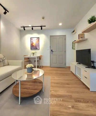 Modern living room with stylish decor, wooden flooring, and cozy seating area.