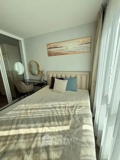 Cozy bedroom with stylish decor and ample natural light, featuring a plush bed and elegant furnishings.