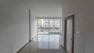 Spacious empty room with large windows offering natural light and modern design.
