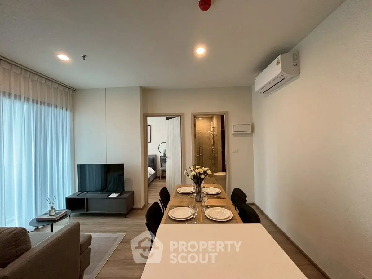 Modern living room with dining area and air conditioning in a stylish apartment.