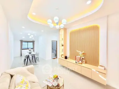 Modern living room with elegant lighting and open dining area, featuring stylish decor and cozy ambiance.