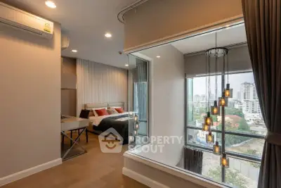Modern bedroom with large window offering stunning city view and elegant lighting fixtures.