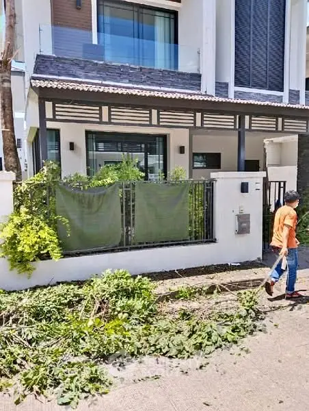 Modern townhouse exterior with landscaped front yard and contemporary design.