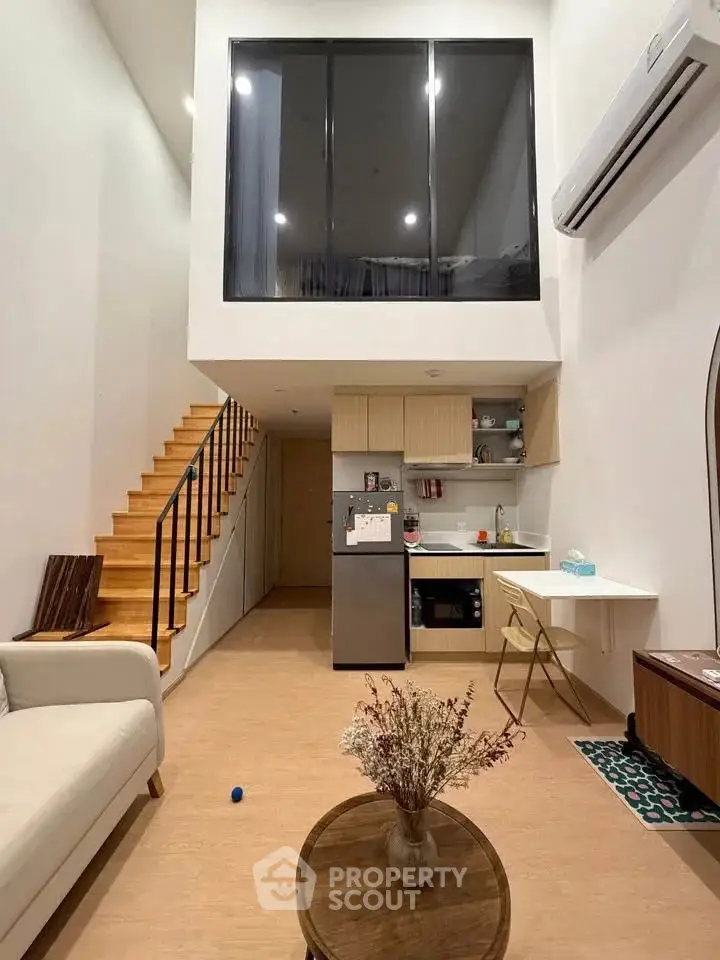 Modern loft apartment with high ceilings, stylish kitchen, and cozy living area.