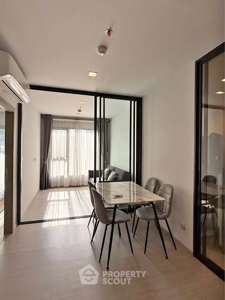 Modern open-plan living and dining area with natural light and stylish furniture.
