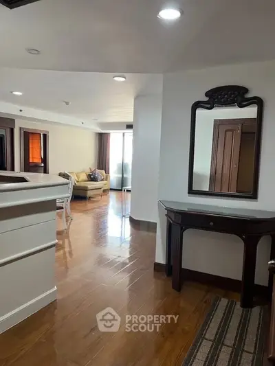 Spacious living area with elegant wooden flooring and stylish furniture