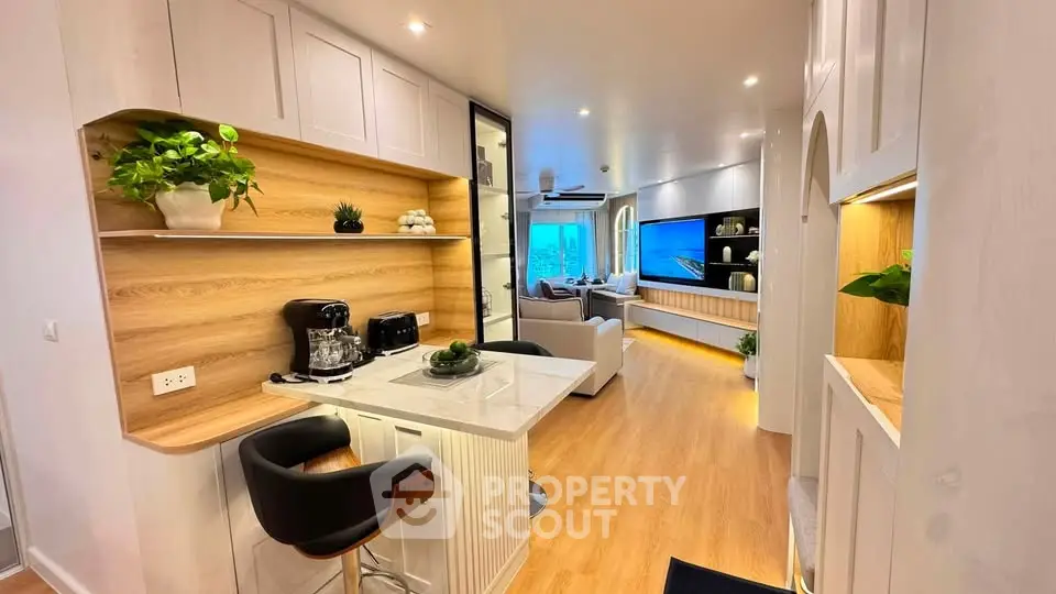 Modern open-layout kitchen and living room with stylish decor and wooden flooring.
