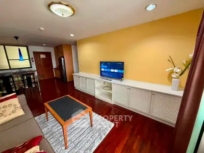 Spacious living room with wooden flooring and modern decor in a stylish apartment.