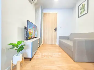 Modern living room with sleek furniture and wooden flooring, featuring a flat-screen TV and stylish decor.