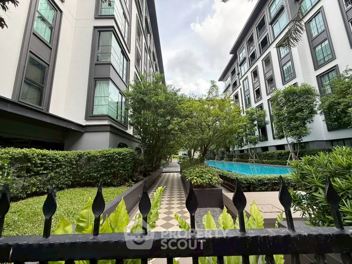 Modern apartment complex with lush garden and inviting pool