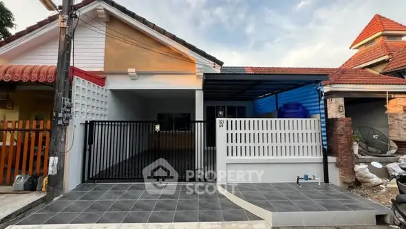 Charming single-story house with modern facade and gated driveway in a serene neighborhood.