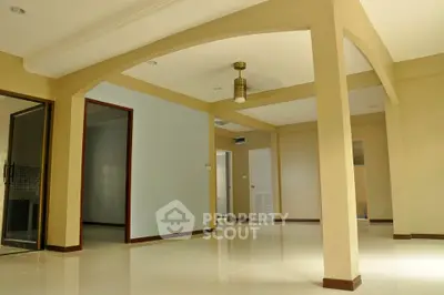 Spacious open-plan living area with elegant archways and neutral tones.