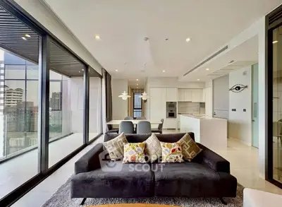 Luxurious modern living room with open kitchen and stunning city view.