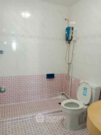 Spacious bathroom with modern shower and tiled flooring in a real estate property.