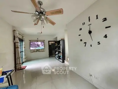 Spacious living room with modern decor and large wall clock