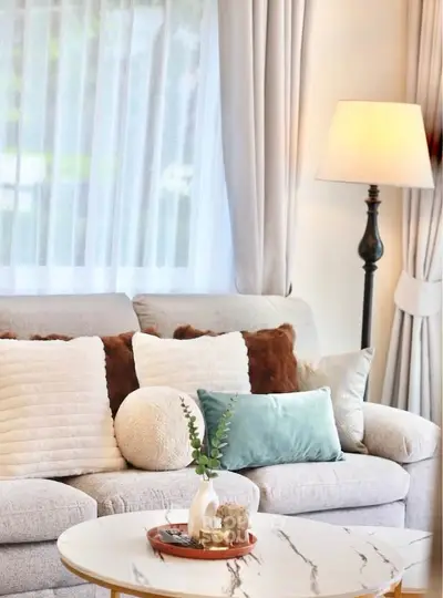 Elegant living room with plush sofa, stylish cushions, and a chic marble coffee table.