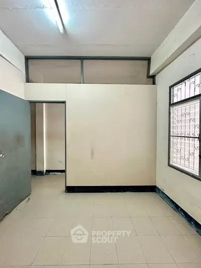 Spacious room with tiled flooring and natural light, ideal for versatile use in a real estate property.