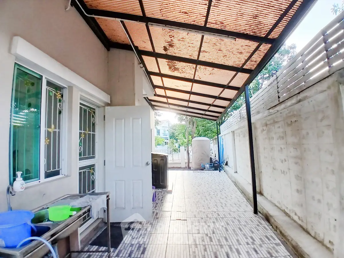 Spacious outdoor area with tiled flooring and covered roof, ideal for versatile use.