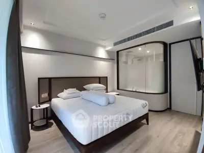 Modern bedroom with elegant design and frosted glass shower partition