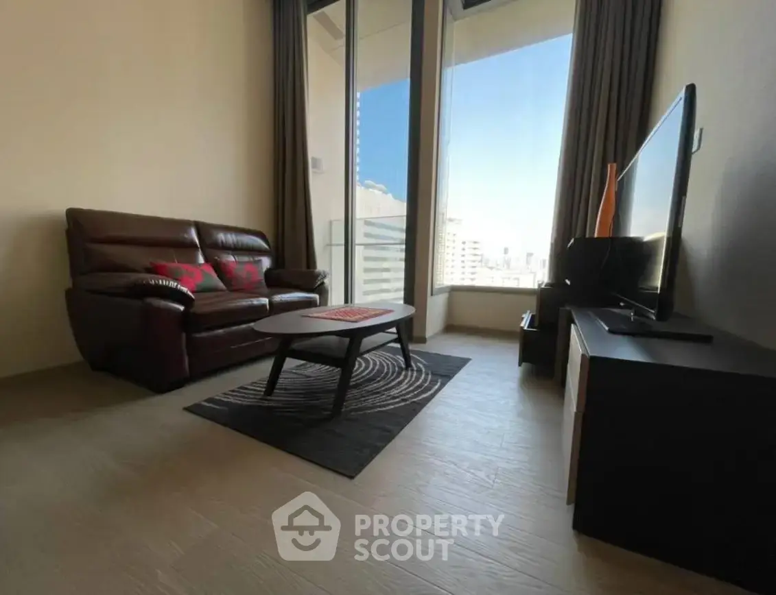 Modern living room with leather sofa and city view from large window.