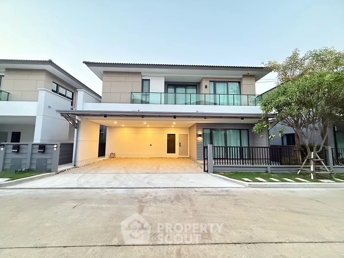 Modern two-story house with spacious driveway and elegant facade in a serene neighborhood.