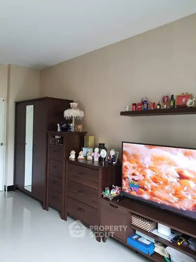 Cozy living room with modern TV setup and elegant wooden furniture