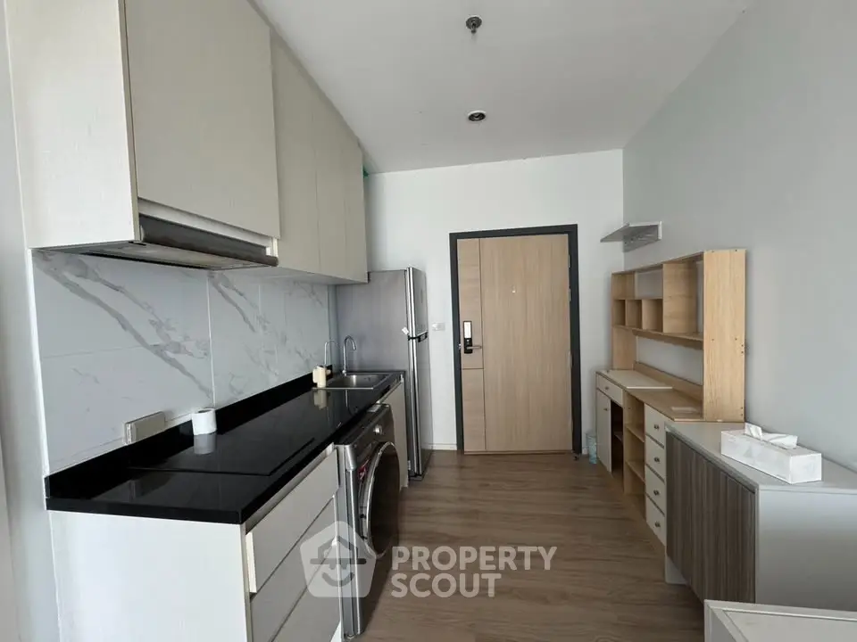 Modern kitchen with sleek cabinetry and appliances in a stylish apartment