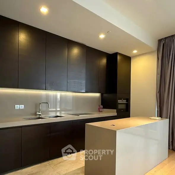 Modern kitchen with sleek dark cabinets and minimalist island