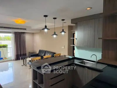 Modern open-layout kitchen and living room with stylish lighting and balcony view.