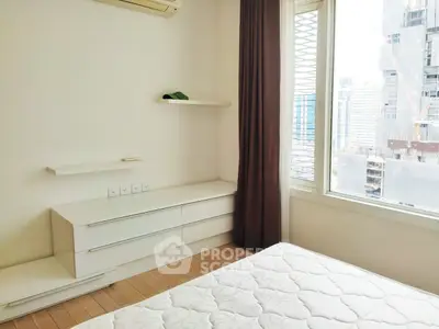 Bright bedroom with modern furniture and city view, perfect for urban living.