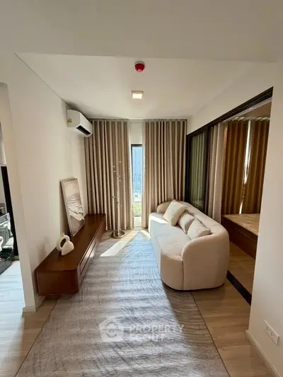 Stylish living room with modern sofa and floor-to-ceiling curtains in a cozy apartment.