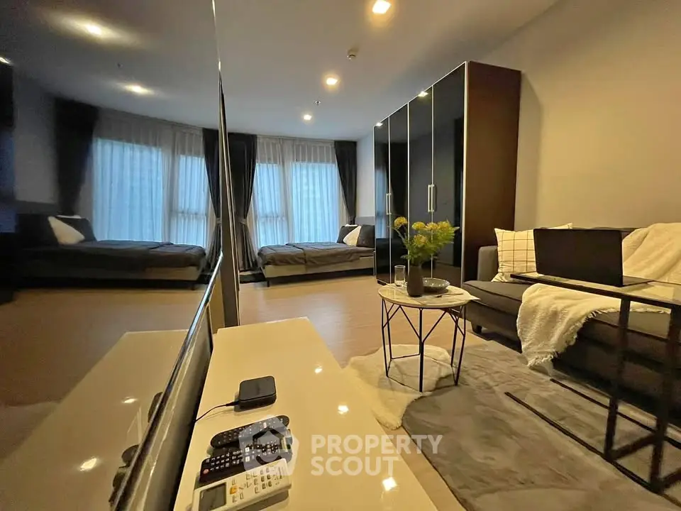 Modern living room with sleek design and cozy ambiance, featuring a stylish sofa and large windows.
