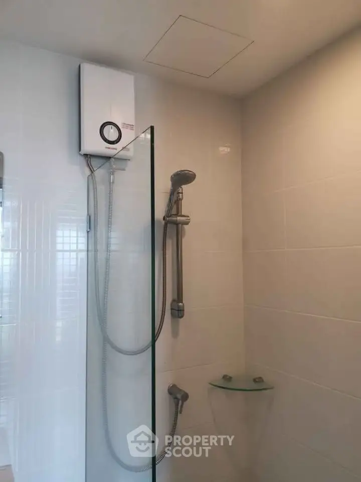 Modern bathroom with sleek shower and water heater in a contemporary home.
