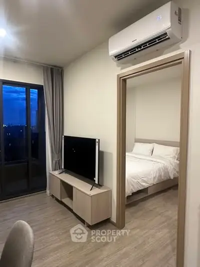 Modern apartment with bedroom view, air conditioning, and sleek TV setup.