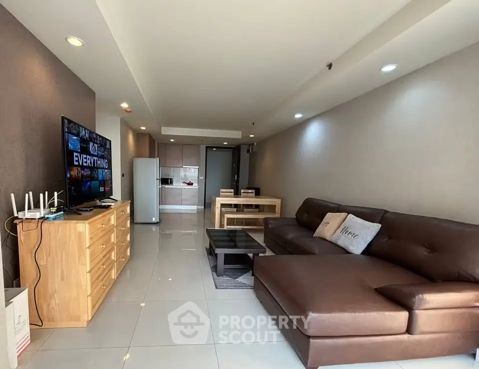 Spacious modern living room with sleek furniture and open kitchen layout