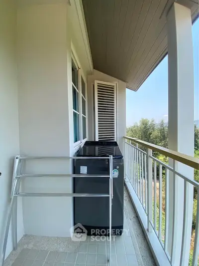 Charming balcony with washing machine and scenic view, perfect for urban living convenience.