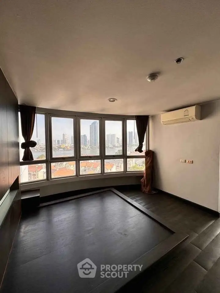 Spacious room with panoramic city view and large windows, ideal for modern living.