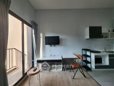 Modern studio apartment with balcony and compact kitchen, featuring sleek furniture and natural light.