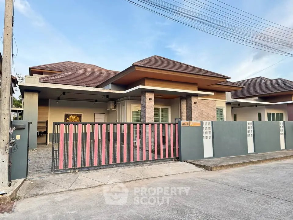 Modern single-story house with spacious driveway and stylish gate in a serene neighborhood.