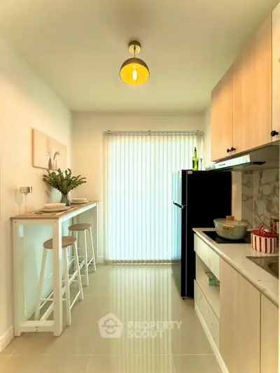 Modern kitchen with sleek design, featuring a breakfast bar and ample natural light.